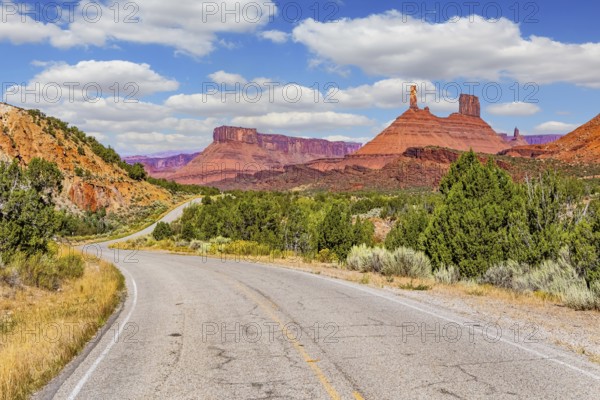 The reds and browns of Utah's vibrant landscapes. Wide asphalt highway among picturesque hills and