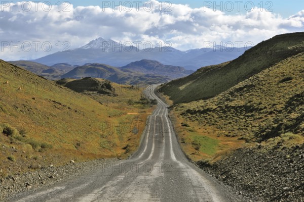A gravel road winds among the hills and mountains. Chilean Patagonia. Summer in the national park