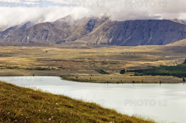 Lake Tekapo and the surrounding hills under clouds, South Island, New Zealand