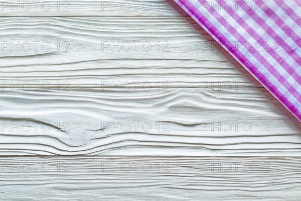 Pink checked towel on wooden board copy space