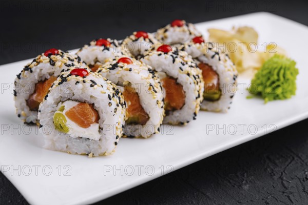 Food, Delicious sushi rolls with salmon, avocado, and sesame seeds served on a sleek plate,
