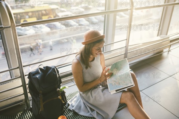 Waiting, delayed transport in the terminal of the airport or train station. Young caucasian woman