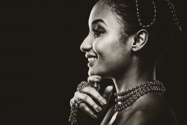 Upscale Indian woman wearing chain jewellery and beautiful makeup. Black and white photo.