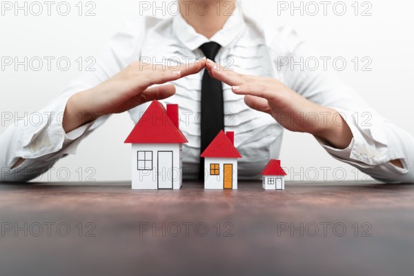 Protecting Hands Over House, Home Security And Protection Concept. hands holding paper, family