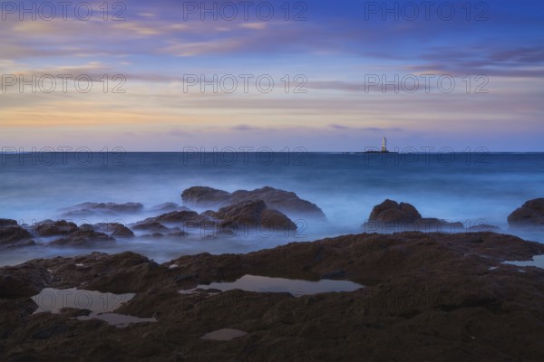 Long exposure view of the Sant'Antioco island coast and the Mangiabarche Lighthosue at sunrise on