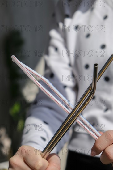 Woman holding Reusable Metal and plastic drinking Straws. Female Hand on reusable collapsible