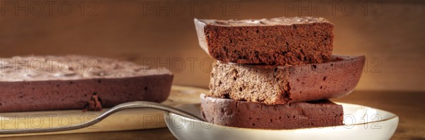 Chocolate brownie panorama, simple coffee cake, a side view shot on a dark rustic wooden