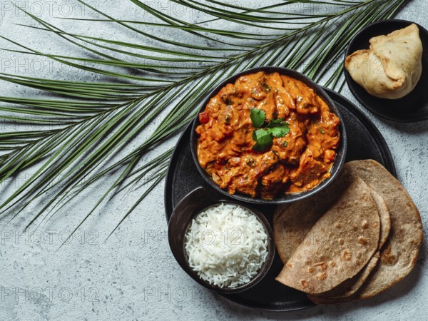 Indian cuisine dishes: tikka masala, rice, samosa, chapati, . Indian food on gray stone background