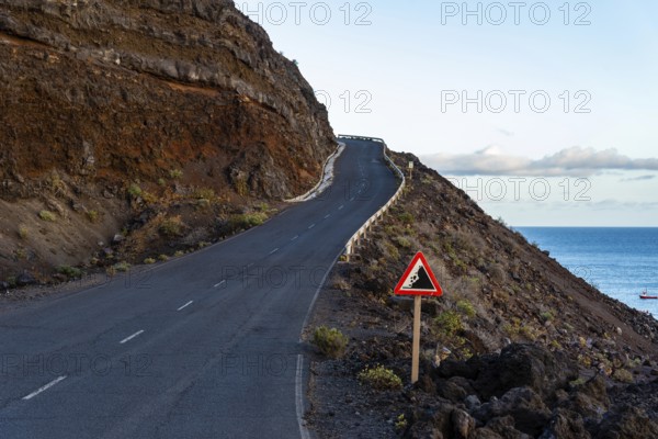 Empty road with risk of landslide traffic sign in a volcanic landscape in the Island of La Palma,