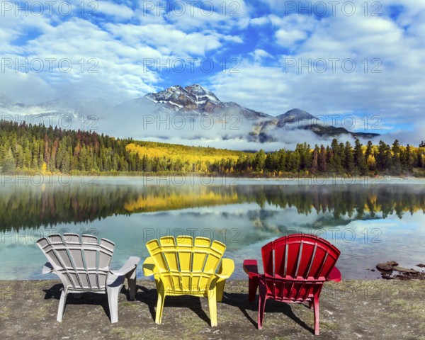 Rocky Mountains of Canada. Three comfortable multi-colored deck chairs stand by the Piramid lake.