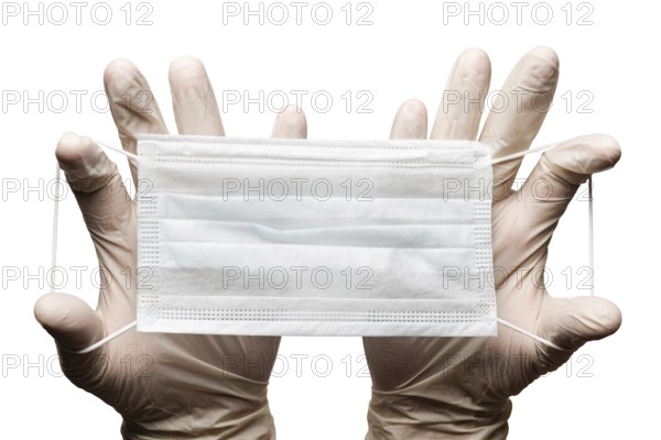 Doctor holding surgery medical face mask in hands in gloves isolated on white background. Medicinal