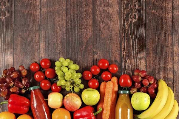 Trauben, Orangen, Tomaten, Äpfel, Bananen, Paprika und natürlichen Saft auf hölzernen Hintergrund,