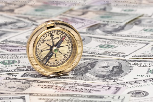 Many dollar banknotes and compass. Symbolic photo for economic crisis Austria