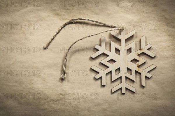 Vintage wooden snowflake string on paper background holidays concept
