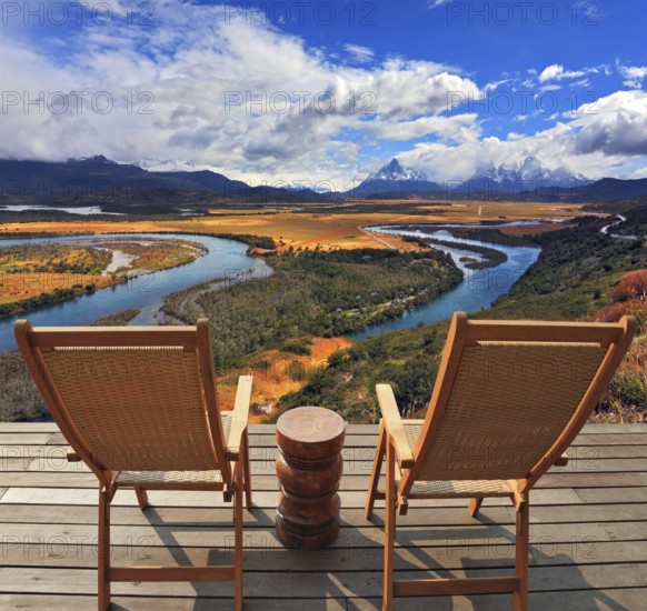 Two wooden chairs - on a wooden platform. Charming rural idyll. Clouds reflected in the smooth