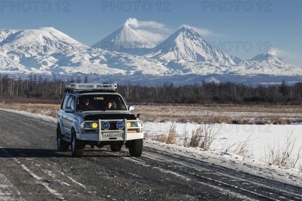 Japanese Sport Utility Vehicle Toyota Land Cruiser driving along road on background beautiful