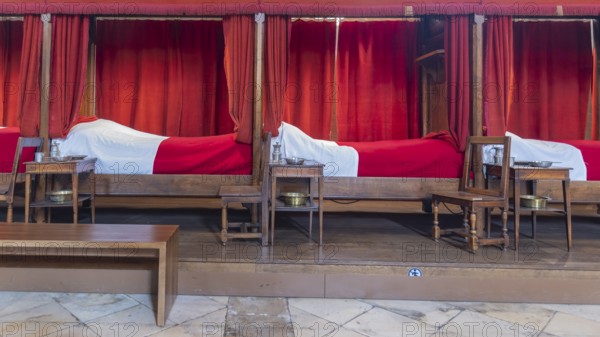 Beaune, France - April 29, 2024: Interior of main room with red beds at Hospices de Beaune or