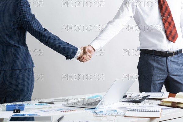 Businessman and businesswoman handshaking after good deal. Business consultation and cooperation in