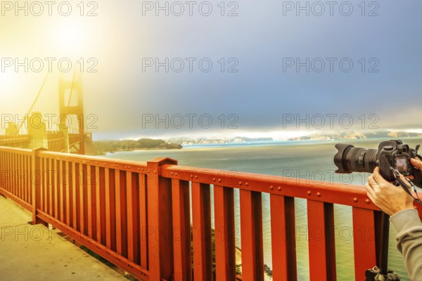 Camera taking a shot of Golden Gate Bridge and red railing, San Francisco, California, United