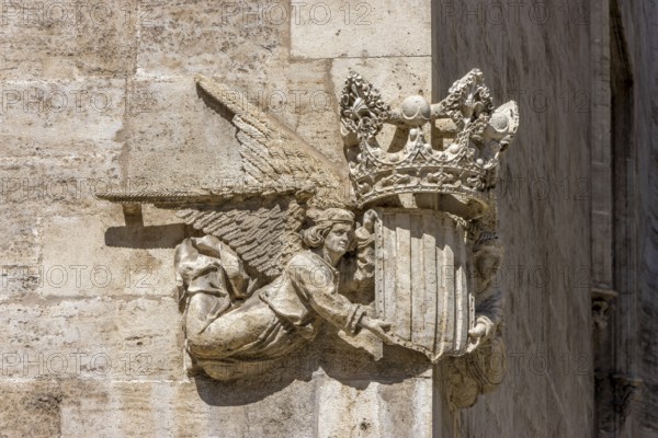 Stone sculpture of two angels with the coat of arms and crown of Valencia on the corner of a stone