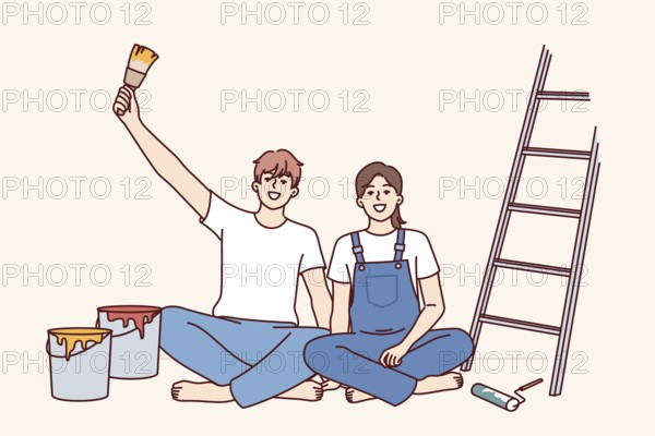 Couple makes repairs in apartment with own hands and sits on floor near ladder and buckets of paint