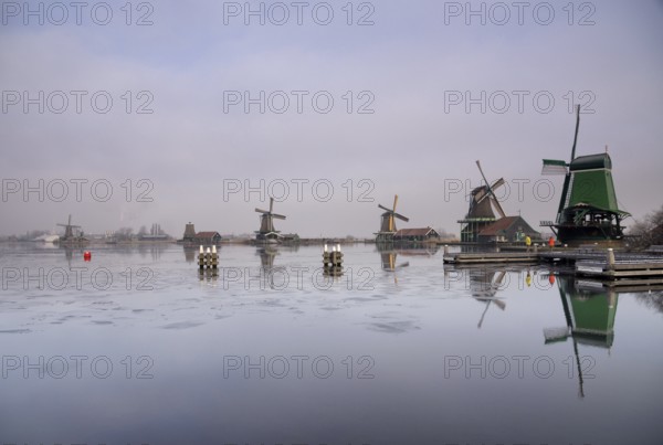 Windmills along the river Zaan in the Dutch traditional village Zaanse Schans which is one of the