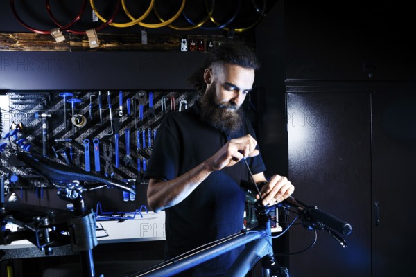 Theme sale and repair of bicycles. Young and stylish with a beard and long hair, a Caucasian man