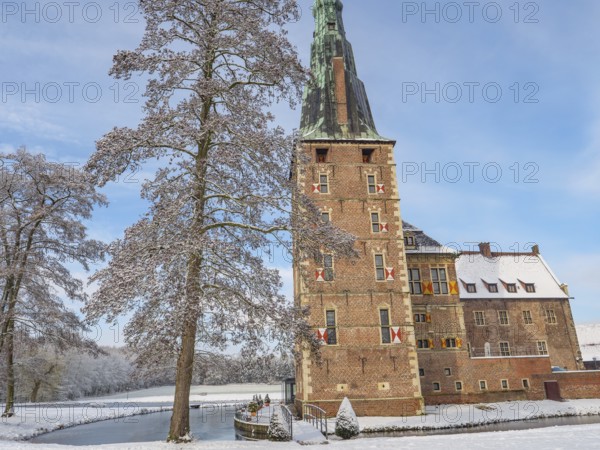 A castle with high towers, snow-covered trees and a clear sky in winter, raesfeld, münsterland,