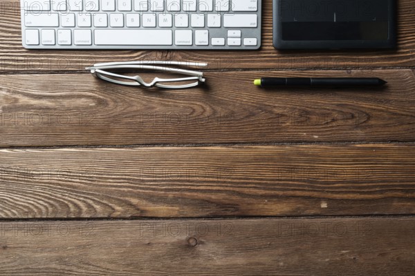 Top view office workspace composition. Flat lay vintage wooden desk with pc keyboard and graphic