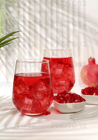 Pomegranate fruit juice and ingredients, summer pomegranate drink on bright table, detox diet and