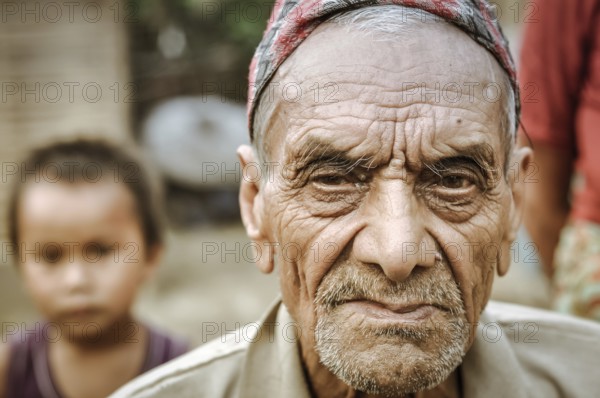 Damak, Nepal, circa May 2012: Old frowning man with beard and wrinkles on his face at Nepali