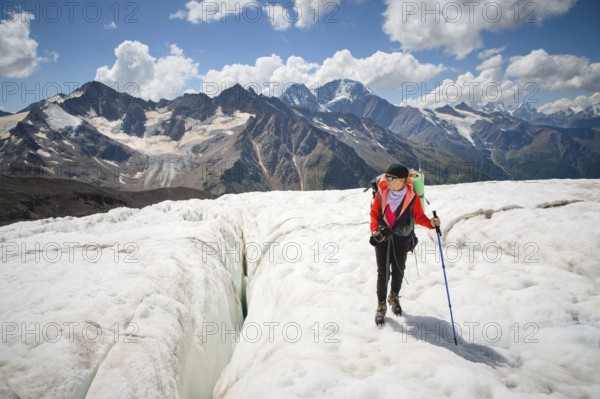 Female mountaineer enjoying the beauty of the glacier walks on the glacier in the crampon and