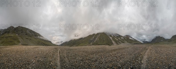 Panoramic view of hiking trail in glacial valley high up in Kashmir mountains in India on cloudy