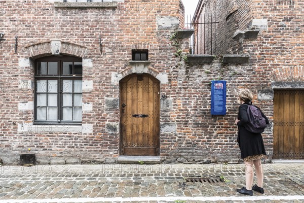 Tournai Doornik, Walloon Region, Belgium, 08 14 2019 Local tourist in summer dress looking at the