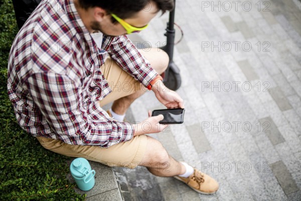 Caucasian man uses modern technologies Internet and cellular communication on smartphone while