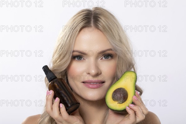 A model elegantly showcasing avocado along with beauty oil specifically designed for natural