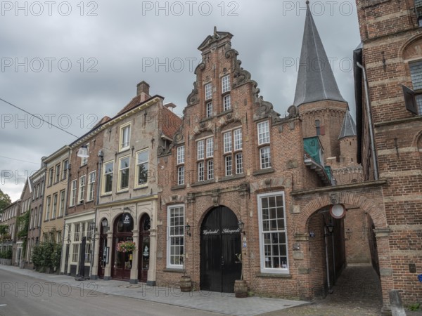 Historic houses and a church tower in a quiet street under a cloudy sky, zutphen, gelderland,