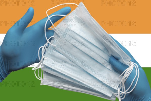 Doctor holding face masks in hands medical blue gloves on background national flag of India.