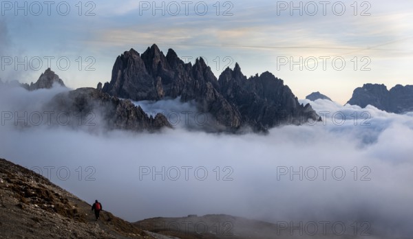 Unrecognised man trekking late in the evening at the hikking path of the picturesque Dolomites at