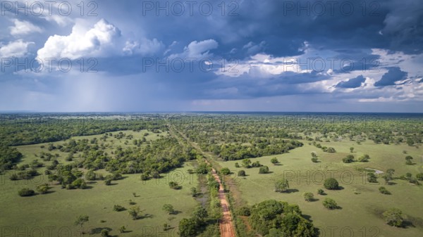 Aerial view of Transpantaneira dirt road with dramatic sky and rain crossing the typical landscape