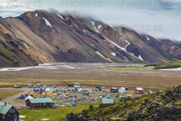 Pink and green rhyolite mountains surround the flat valley of the National Park Landmannalaugar.