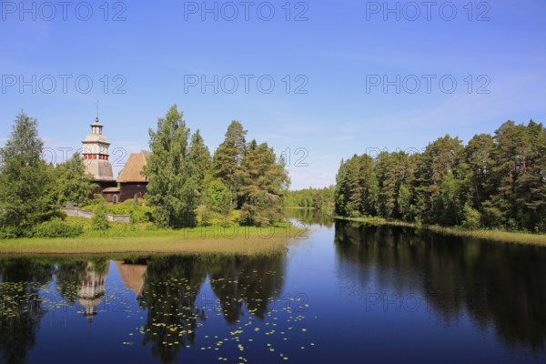Finnish blue lake and sky landscape with UNESCO World Heritage site, old wooden church of