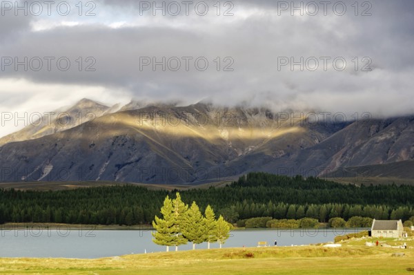 Sun breaking through the clouds over Lake Tekapo and the Church of the Good Sheppard on the South