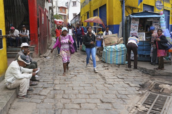 Antananarivo, Madagascar - April 24, 2019: Two unknown young Malagasy girls walking cobblestone