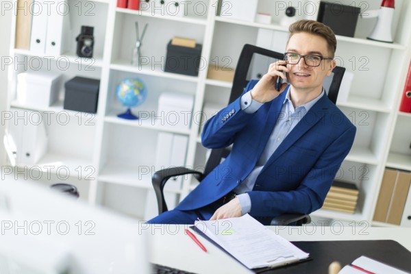 Casual businessman working in office, sitting at desk, typing on keyboard, looking at computer