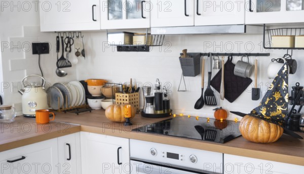Decor of the white classic kitchen with pumpkins for Halloween and harvest. Autumn mood in the home