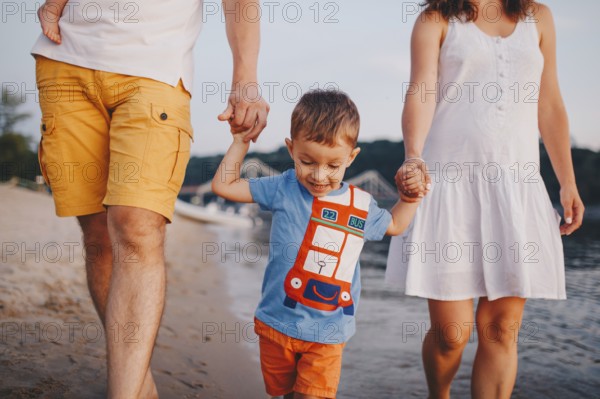 Family holiday in summer. Young Caucasian family foot walking barefoot sandy beach, shore river