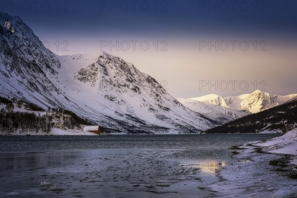 Beautiful winter landscape scene mountain in background in Northern Norway. sunset or sunrise in