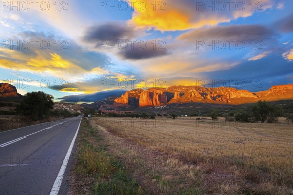 Red sunset. The magnificent Mallets of Riglos cliffs. Scenic paved highway. Romantic trip to Spain.