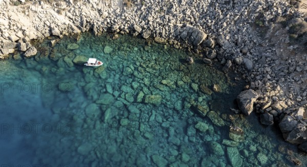 Drone aerial seascape with luxury yacht moored on the coast. Blue water Summer vacations in the sea